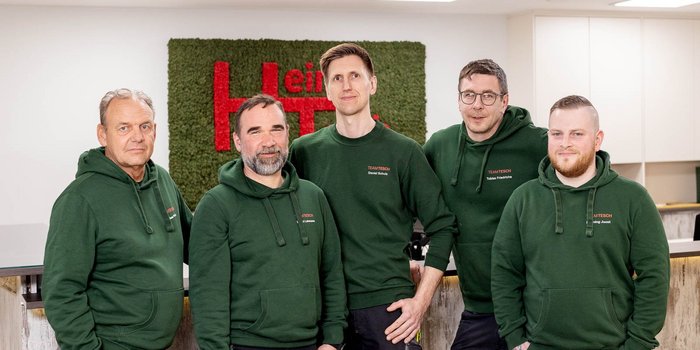 Monteurteam von Heinz Tesch vor dem Firmenlogo