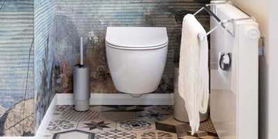Ein modernes Badezimmer mit einer schwebenden Toilette, dekorativen Fliesen und einem eleganten Handtuchhalter an der Wand.
