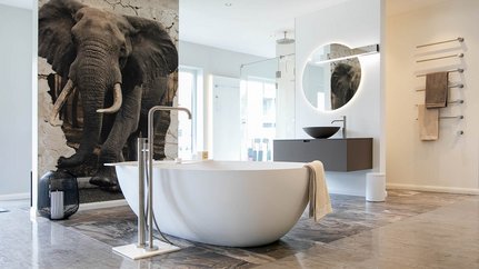 Elegantes Badezimmer mit beeindruckendem Elefantenmotiv an der Wand Elegantes Badezimmerdesign mit einer weißen Badewanne, einem runden Spiegel und einem großen Elefantenmotiv an der Wand.
