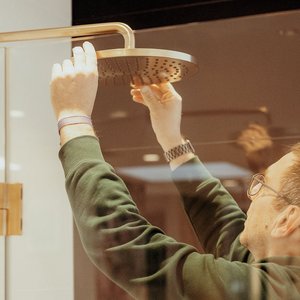 Mitarbeiter montiert Badtechnik in einem modernen Badezimmer