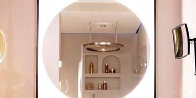 Modern gestaltetes Badezimmer mit Spiegel und Designarmaturen